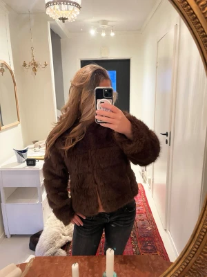 Mörkbrun pälsjacka  - Snygg mörkbrun pälsjacka (fuskpäls) från Gina Tricot. Bara använt några få gånger. Nypris är 1000kr något.