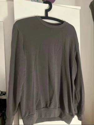 Mörkgrå basic sweatshirt - En enkel mörkgrå. Perfekt för en avslappnad look och lätt att matcha med jeans eller mjukisbyxor. Lite oversized