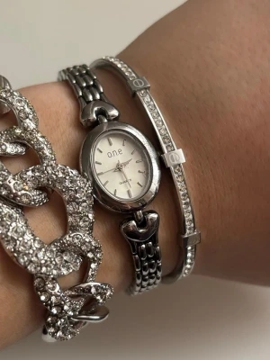 Silverfärgad klocka  - Minimalistisk klocka. Varsamt använd och i mycket bra skick. Nytt och fungerande batteri. Priset är inte hugget i sten. 