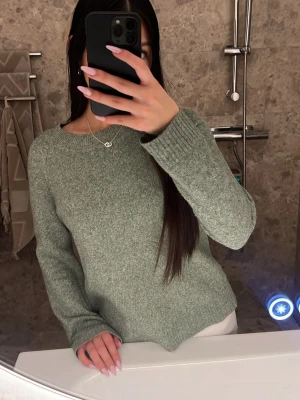 Grön stickad tröja - Mysig stickad tröja från Vero Moda med rund halsringning och långa ärmar. Tröjan har ribbade muddar vid ärmslut och nederkant. Ordinarie pris 299kr! Super mysig, skriv för fler bilder eller vid fundering 