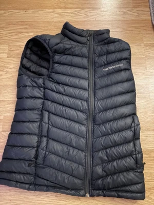 Svart dunväst från Peak Performance - Säljer en peak performance väst i storlek S som ej kommer till användning.