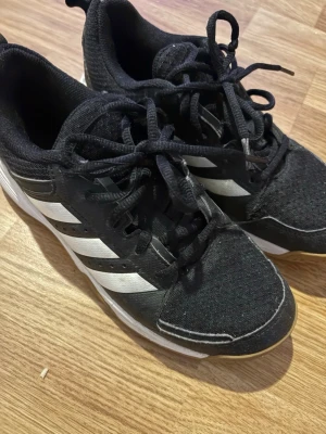 Svarta adidas sneakers med vita ränder - Svarta adidas, för inomhus gympa/fotboll/idrott. I använt fint skick. Stl 37 1/3 