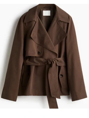 Brun trenchcoat med bälte - Så snygg stilren brun trenchcoat med bred krage och knytskärp i midjan. Jackan har långa ärmar och stora knappar framtill. 