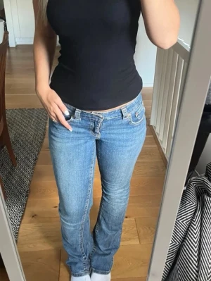 Blå jeans  - Säljer ett par klassiska blå jeans med hög midja och raka ben. Jeansen har fem fickor, knapp- och dragkedjestängning samt snygga sömmar. Perfekta för en chill och stilren look. Aldrig använda för fel storlek🤗