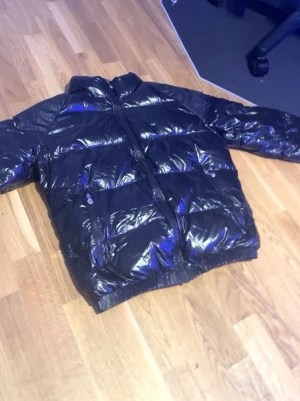 Pyrenex dunjacka svart M – äkta puffer vinterjacka - Säljer en svart Pyrenex dunjacka i storlek M. Stilren puffer med blank finish som passar perfekt för höst och vinter. Jackan är varm men lätt, fylld med äkta gåsdun och mycket bekväm att bära. I mycket bra skick utan hål, fläckar eller skador. Original Pyrenex-logga på ärmen. Kommer från rök- och djurfritt hem. Pris: 3650 kr. Skickas snabbt och packas noggrant. Hör av dig vid frågor eller om du vill ha fler bilder.