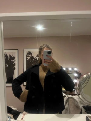 Mörkblå kort kappa med dubbelknäppning - Mörkblå kort ull kappa! Enkel och stilren design som funkar till många outfits. 