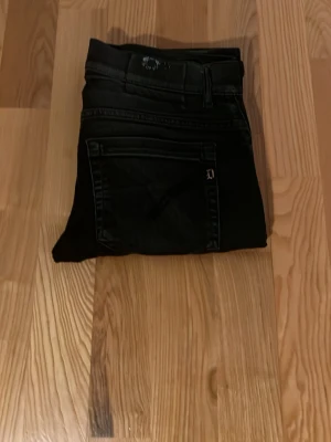 Svarta skinny jeans från Dondup - Svarta jeans från dondup med klassisk femficksdesign och smal passform. Jeansen har diskreta sömmar och en stilren look som passar till det mesta. Materialet är jeans och färgen är helsvart.