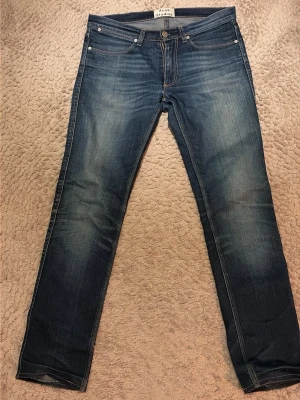 Blå jeans från Acne Studios - Snygga blå jeans från Acne Studios med  snygg wash och raka ben. Storlek 31. Längd: ca 100cm, midja: ca 43cm, innerbenslängd: ca 79cm