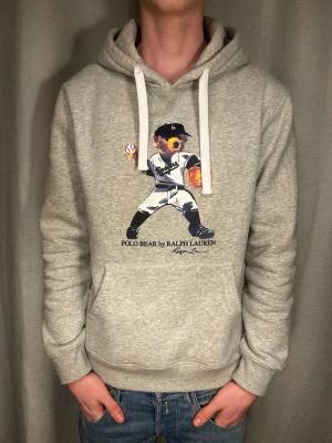 Ralph lauren hoodie  - Säljer en grå Ralph lauren hoodie. Står att den är L men sitter mer som en M. Modellen på bilden är 183 o väger 70 kg. Skriv vid minsta fundering.