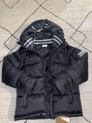 Burberry jacka  - Svart burberry jacka. Storlek M. Helt ny. Man kan även ta av ärmarna så det blir en väst. Passar hela året om. Hör av er vid funderingar.