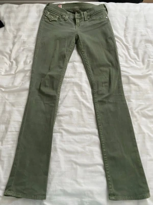Gröna true religion jeans - Snygga gröna true religion jeans med klassisk bootcut passform. Jeansen har fem fickor, bälteshällor och knappgylf. Jättesköna och snygga.