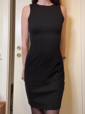 Svart Tight Figurnära Ärmlös Klänning Fodralklänning Zalando - Säljer en svart, ärmlös klänning med rund halsringning och figurnära passform. Klänningen har en enkel och stilren design. Perfekt för dig som gillar minimalistisk och tidlös stil. Passar både till vardags och fest.