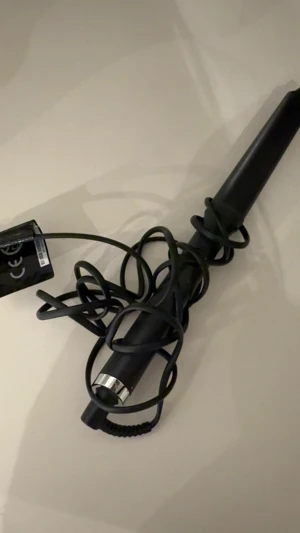 ghd Curve Wand Creative Curl  - Säljer en svart ghd Curve Wand Creative Curl locktång med konformad stav och silverdetalj. Perfekt för att skapa snygga, naturliga lockar. Kommer med originalförpackning. Sladd medföljer. Stilren och enkel att använda för trendiga frisyrer.