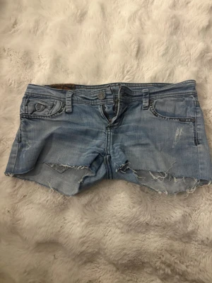 Ljusblå låga jeansshorts  - Säljer ett par super fina ljusblå jeansshorts, köpta second hand utomlands så vet tyvärr inte vilket märke de är ifrån. De är väldigt Lågmidjade och ganska korta!❤️