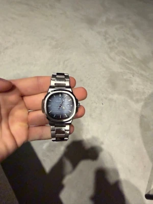 Blå och silverfärgad klocka Poedagar - Säljer en stilren klocka från Poedagar med blå urtavla och silverfärgad länk i metall. Klockan har datumvisning och klassisk design med markerade index och visare. Perfekt accessoar för dig som gillar en clean look.