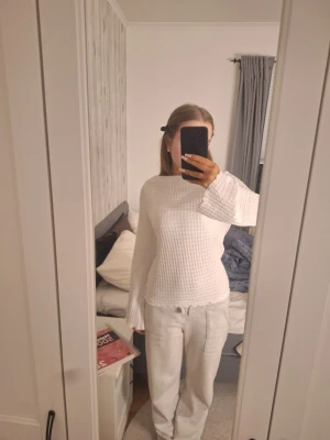 Vit långärmad topp från 157 - Säljer en vit långärmad topp från 157 i storlek S. Tröjan har vågig struktur, utsvängda ärmar och en lätt ribbad känsla. Perfekt för dig som gillar en enkel men ändå unik stil. Superfin att matcha med både jeans och mjukisbyxor.