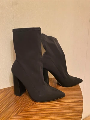 Stretchiga stövletter 37 - Svarta stretchiga högklackade boots med spetsig tå. Public desire/asos. Storlek 37/4  Klack 10,5cm