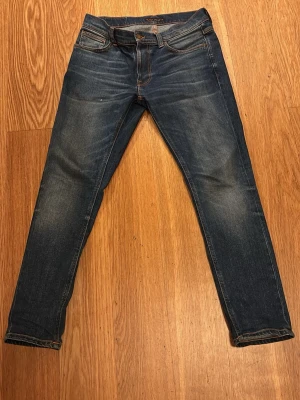 Nudie Jeans Lean Dean Indigo Shades - Säljer ett par Nudie Jeans Lean Dean i färgen Indigo Shades. De har klassisk femficksdesign, smal passform och är tillverkade av 99% ekologisk bomull. 