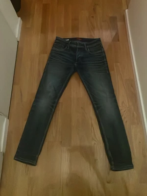 Slim fit blå jeans Slim Fit/Tim - Snygga blå jeans i slim fit-modell med klassisk femficksdesign och diskreta slitningar. Jeansen har normal midja och raka ben, tillverkade i mjukt denimtyg. Passar perfekt till en avslappnad stil och är riktigt bekväma. Passform w29/L30