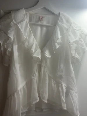 super gullig volang blus!!  - säljer denna suuuper söta volang blusen från Nelly i storlek 36! 💗 den är bara använd ett fåtal gånger och har inga stora eller märkbara defekter. Tröjan går upp lite grann vid magen och är ganska kort. Skriv mer för bilder på eller frågor 💗