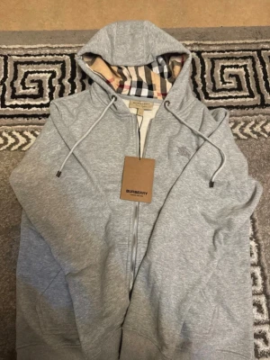 Burberry zip up  - Säljer denna sköna och snygga tröjan som passar för både vinter och sommaren. Aldrig använd förr och känns otrolig när den används då man skiner av själv säkerhet. Den passar för både S och M