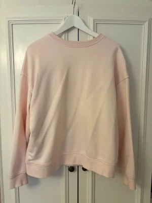 Ljusrosa sweatshirt från Lindex - En enkel och mjuk ljusrosa sweatshirt från Lindex. Tröjan har rund halsringning, ribbade muddar och en relaxed passform. Perfekt för chill dagar eller när du vill ha något bekvämt och stilrent.