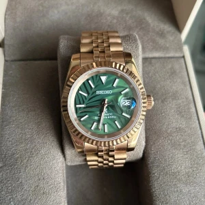 Seiko Mod klocka  - Säljer nu en riktigt snygg seiko klocka som är modifierad. Klockan är en automatisk klocka med måttet 39 mm. Märke: Seiko. Urverk: NH36A. Glas: Safir. Armband: Rostfritt stål.  Klockan är i mycket bra skick och allt fungerar som det ska. Klockboken till höger medföljer! Skriv till mig om ni har några funderingar, jag är även öppen för bud!