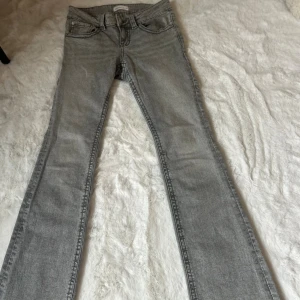 Grå bootcut jeans - Snygga grå jeans från Perfect Jeans Gina tricot i bootcut-modell. Jeansen har klassisk femficksdesign, coola bakfickor med lock och knapp, samt en bekväm midja. Perfekta för dig som gillar en avslappnad men trendig look.