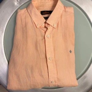 Morris linneskjorta - Säljer en persikofärgad/rosa skjorta i 100 % linne från Morris. Inga defekter, pris kan diskuteras. Skriv om ni har fler frågor! 🙌