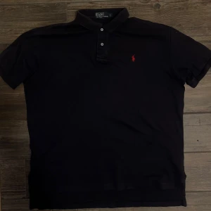 Marinblå pikétröja från Ralph Lauren - Skön piké som framhäver armar och axlar på ett schysst sätt.