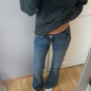 Blå bootcut jeans från Monki - Säljer ett par blå bootcut jeans från Monki med snygga broderade rosetter i gult på bakfickorna. 💗Jeansen är lågmidjade och är i nyskick då jag knappt använt de❣️pris kan diskuteras!