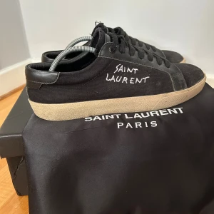 Saint Laurent svarta sneakers - Svarta sneakers från Saint Laurent med handskriven logga på sidan. Skorna är i bra skick men man ser att dem är använda, allt og ingår, storlek 41, pris fråga gärna om fler bilder eller diskutera priset!🤝🏻