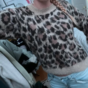 Leopardmönstrad stickad tröja - Supermysig stickad tröja med leopardmönster i beige, brunt och svart från kahppal. Tröjan har rund halsringning, ribbade muddar och lång ärm. Perfekt nu för hösten🤎