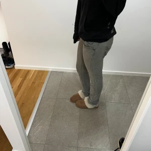 Grå Replay jeans med broderade fickor - Säljer ett par grå jeans från Replay med snygga broderade detaljer på bakfickorna. Jag är 160cm lång. Waist 30, Length 34.