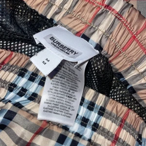Rutig Burberry shorts i bomull - Snygga shorts från Burberry i klassiskt rutigt mönster med beige, svart, vitt och röda detaljer. De har elastisk midja och är tillverkade i mjuk bomull med lite stretch. Perfekta för en chill och trendig sommarlook.