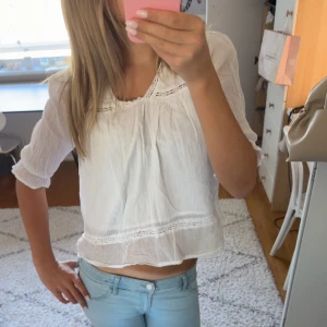 Vit blus från Gina Tricot - Superfin vit blus från Gina Tricot med trekvartsärmar och snygga spetsdetaljer vid halsringning och nederkant. 