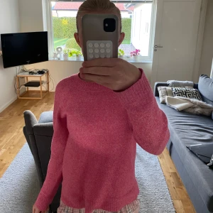 Rosa stickad tröja från Vero Moda - Superfin rosa stickad tröja från Vero Moda i storlek XS. Tröjan har en klassisk rund halsringning och långa ärmar. Perfekt att slänga på sig när det är lite kyligare ute. Enkel och snygg att matcha med jeans eller kjol.