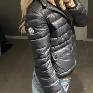 Svart Moncler dunjacka - Säljer en jättefin moncler jacka som jag köpt här på Plick. Den har några defekter och det är några små hål som inte man ser vid användning och att dragkedjan var sönder när jag köpte den. Men jag åkte till en sömmerska och hon lagade den! Så nu är den hel vid dragkedjan. Skriv för frågor eller funderingar🫶🏼storlek xs