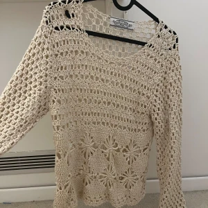 Beige virkad tröja från Atmosphere - Säljer en beige virkad tröja från Atmosphere med lång ärm och snyggt blommönster nertill. Tröjan är stickad i bomull och har en luftig, bohemisk känsla med genombrutet mönster. Perfekt för lager-på-lager och chill stil.