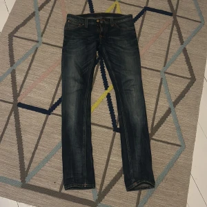 Blå jeans från Nudie Jeans - Snygga blå jeansbyxor från Nudie Jeans i modellen Tight Long John. Köpta begagnade på nudies butik. Storlek står inte i dem men sitter som ett par W30/L30