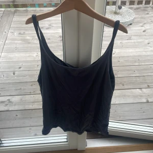 blå/grå linnetopp från H&M Basic - En enkel blå/grå linnetopp från H&M Basic med smala axelband och rak passform. Perfekt att styla med jeans eller kjol för en clean look. Tillverkad i mjuk bomull som känns skön mot huden. 