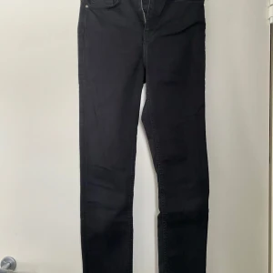 Shaping jeans strl W27 - Säljer ett par svarta shaping jeans i super skinny modell. De är högmidjade och har en tight passform som framhäver figuren. Perfekta för både vardag och fest!