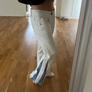 Vita jeans - Jättesnygga vita jeans från gstar raw med coola detaljer. Omsydda till flaired därav det blåa på sidan. Passar mig som är ca 160 perfekt i längden men är tyvärr lite stora. Strlk 27 i midjan