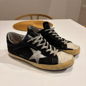Golden Goose  - Tja! Säljer nu dessa Golden Goose superstar pga inhe kommer till användning. De är en strl 42/43 och passar om man har strl 42/43. Finns 1-2 defekter på skorna. Den ena ser ni på bild 3(hälen är sliten) den andra är att sulan i hälen på bild 4 är lite sliten men inget man märker av. Nypris 5500kr. Hör av vid frågor😀. Pris kan diskuteras✌🏽😎