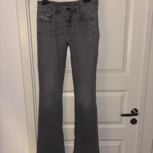 Grå lågmidjade bootcut jeans från Diesel - orginalpris: inte helt säker med runt 1400kr jätte fina jeans från Diesel köpta på zalando.  Säljer då de tyvärr inte passar längre. har använts några få gånger men inga defekter, förutom lappen på bild 2 Storleken är W25 L32. 