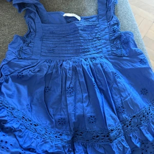 Blå blus med broderade detaljer - Supersöt blå blus med volang och broderade blommor. 