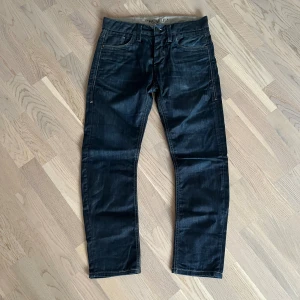 Mörkblå jeans från Jack & Jones - Snygga mörkblå jeans från Jack & Jones Premium med klassisk femficksdesign och kontrastsömmar. Jeansen har rak passform och normal midja, tillverkade i ett mjukt bomullstyg med lite stretch för extra komfort. OBS! (Inner längd 61cm)