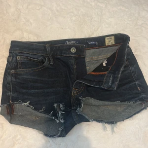 Mörkblå jeansshorts från Crocker - Säljer ett par mörkblå jeansshorts från Crocker, modell Pep! Boot. De är lågmidjade och korta. Passar bra till det mesta och är i ett stretchigt skönt material. 