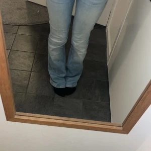 Ljusblå bootcut jeans från Bershka - Säljer ett par ljusblå jeans från Bershka med bootcut passform och låg midja. De är ganska slitna vid fötterna därför annorlunda pris från det andra paret💗skriv för fler bilder💕