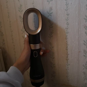 Multistyler hårfön med borstar - Säljer en svart och guldig multistyler hårfön med två utbytbara borstar – en rundborste och en vågig borste. Perfekt för att styla håret med volym och form. Ergonomiskt handtag och modern design, passar dig som vill fixa frisyren snabbt och enkelt.